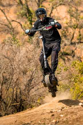Person in protective gear riding an off road escooter