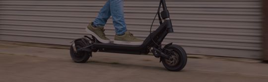 Person riding an escooter on sidewalk