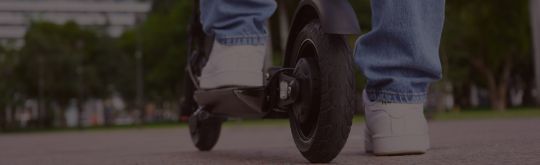 close up of a man standing on an escooter